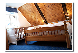 Schlafzimmer mit Kinderbett in der Ferienwohnung "Heuboden".